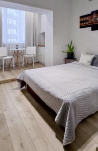 1 dormitorio con 1 cama grande en una habitación blanca en Белая студия на Южном вокзале, en Járkov