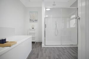 Baño blanco con ducha con puerta de cristal en Spacious Retreat with Backyard Bliss, Sleeps 7, en Bishop Auckland