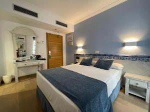a bedroom with a large bed and a kitchen at Hotel Plaza Cavana in Nerja