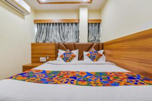 a bedroom with a bed with a wooden head board at FabHotel Silver Inn - CG road in Ahmedabad