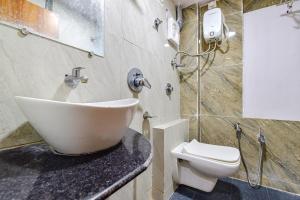 a bathroom with a sink and a toilet at FabExpress Silver Inn in Ahmedabad