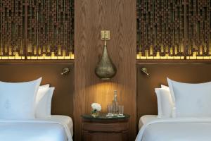 a hotel room with two beds and a vase of flowers at Four Seasons Resort Marrakech in Marrakesh