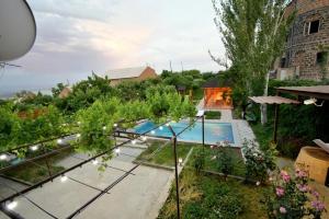 uma vista sobre um quintal com uma piscina em Holliday Villa em Aghtsʼkʼ