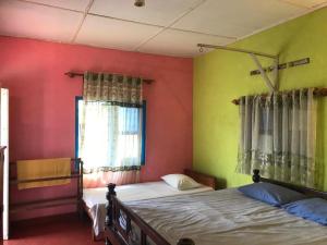 a bedroom with two beds and a window at Sunset Beach Cabana in Ambalangoda