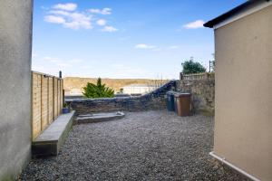 a courtyard with a stone wall and a fence at Dean St Retreat - Cosy Urban Escape, Sleeps 5 in Hexham