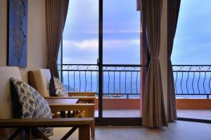 een kamer met uitzicht op de oceaan vanaf een balkon bij Sunshine B&B in Jiufen