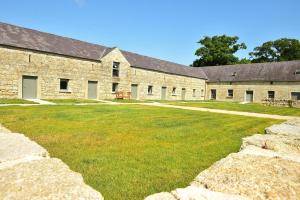 an old stone building with a large yard at Upper Yard Borris House in Borris