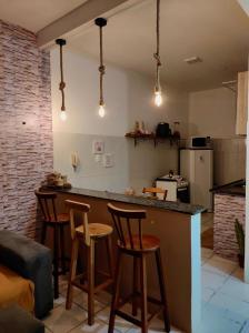 a kitchen with a counter and stools in a room at Ap8 atrás da Passarela do caranguejo- Orla de Atalaia in Aracaju