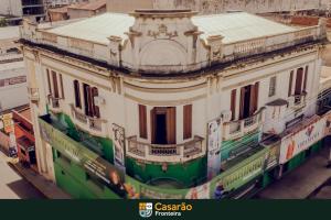 a large white building with a green trim at Hostel Casarão Fronteira in Santana do Livramento