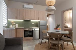 a kitchen and living room with a table and chairs at Num Suites & Lofts Athens in Athens