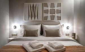 a bedroom with a large bed with two towels on it at Num Suites & Lofts Athens in Athens