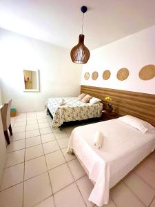 a bedroom with two beds and a pendant light at Ap8 atrás da Passarela do caranguejo- Orla de Atalaia in Aracaju