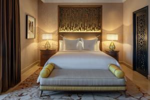 1 dormitorio con 1 cama grande y 2 lámparas en Four Seasons Resort Marrakech en Marrakech