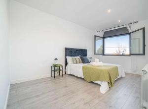 a white bedroom with a bed and a window at Jouvacations Villa Domenec in Figueres +39 photos