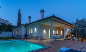 a villa with a swimming pool in front of a house at Jouvacations Villa Domenec in Figueres