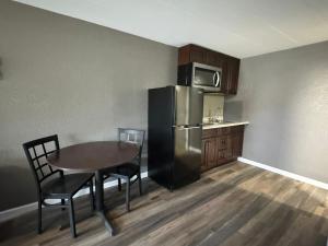 uma cozinha com uma mesa e um frigorífico de aço inoxidável em Residency Inn & Studios em Waynesburg