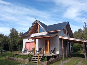 una casa con techo negro en Casa Mallin Azul en El Bolsón