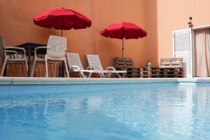 une piscine avec des chaises et des parasols dans un bâtiment dans l'établissement Casa Morales, à Igueste