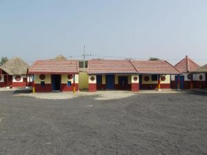 a row of colorful houses with thatched roofs at Rann Kutch Resort in Dhordo