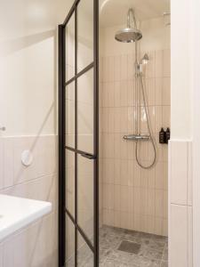 a shower with a glass door in a bathroom at Elite Hotel Mårtenson in Halmstad