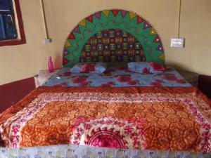 a bedroom with a large bed with a colorful bedspread at Rann Kutch Resort in Dhordo