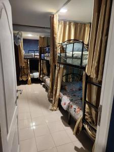 a room with three bunk beds and a doorway at Green Apple Hostel Khaosan in Bangkok