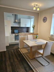 a kitchen with a wooden table and a kitchen with white cabinets at Ferienwohnung Nebelhorn in Dagebüll in Dagebüll