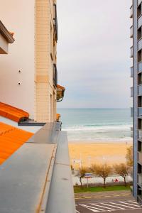 - une vue sur la plage depuis un bâtiment dans l'établissement Ático con terraza en playa de San Lorenzo, à Gijón