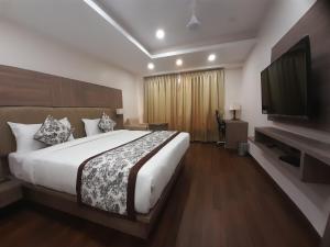 a bedroom with a large bed and a flat screen tv at Variety inn in Patna