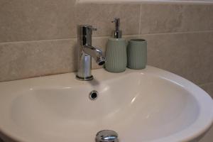 a white sink with two cups on top of it at Terfyn Cottage in Dinorwic