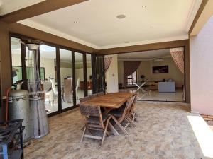 a large room with a wooden table and chairs at 10 Pecanwood Dr 4 Bedroom Beauty in Hartbeespoort