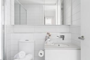 a bathroom with a toilet and a sink and a mirror at Caulfield Elegance: Chic Abode in Melbourne +8 photos