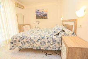 a bedroom with a bed with a blue and white comforter at Mar Azul Litoral - COSTA DORADA in Cambrils