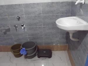 a bathroom with a sink and a toilet and buckets at Rann Kutch Resort in Dhordo