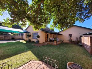 a yard with umbrellas in front of a house at AtHome Apartments in Mokopane
