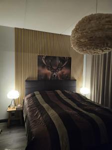 a bedroom with a bed with a deer head on the wall at LuxLapland Cranberry Levi in Levi
