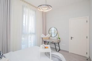 a white bedroom with a bed and a mirror at Tamm - Noor 4 Tower in Dubai