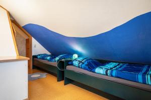 Duas camas num quarto com uma parede azul em Obsthof Mainberger em Kressbronn am Bodensee