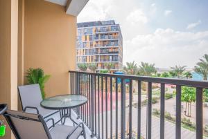 a balcony with a table and chairs and a building at Tamm - Noor 4 Tower in Dubai