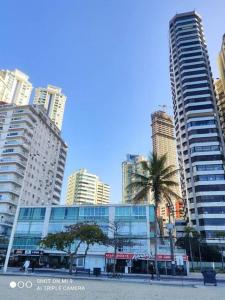 a city skyline with tall buildings and palm trees at Balneário Camboriu 4 quartos Avenida Atlântica in Balneário Camboriú