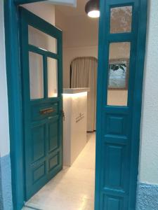 Una puerta azul que conduce a una habitación con un mostrador en Filyra Pension, en Nauplia