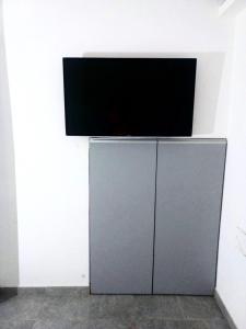 TV de pantalla plana en la parte superior de un armario en Estudio amoblado con cama individual y baño privado en Rosario