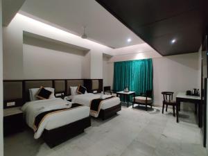 pokój hotelowy z 2 łóżkami i pianinem w obiekcie Hotel Saratharajans w mieście Maduraj