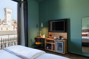 a hotel room with a bed and a desk with a television at The Poet Hotel in La Spezia