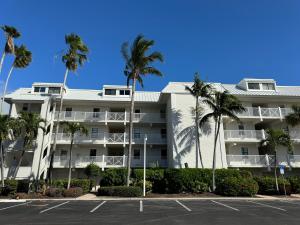 a large white building with palm trees in a parking lot at Captiva Bayside Villas 1 Bedroom 2 Bath - sleep 4 in Captiva