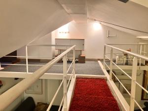 an attic room with stairs and a red rug at Loft Beaubourg - Marais in Paris