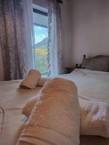 a bedroom with a large bed with a window at Serenity Traditional House in Kalavrita