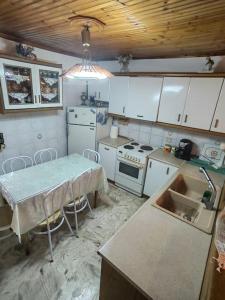 a kitchen with white cabinets and a table and a sink at Serenity Traditional House in Kalavrita