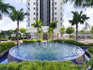 a fountain in front of a building with palm trees at Datum Jelatek Residence, KLCC in Kuala Lumpur