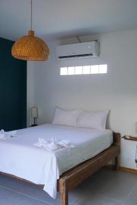 Schlafzimmer mit einem weißen Bett und einem Ventilator in der Unterkunft House Bok Bowie in Koh Rong Sanloem